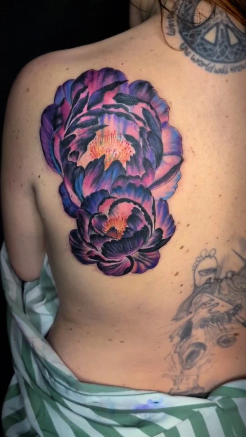 Cover-up d'un ancien tatouage avec des pivoines, couleur.