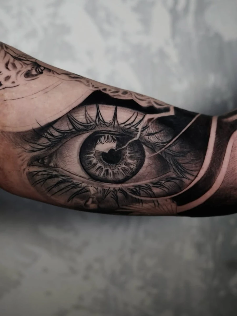 👁️ Œil style surréaliste — partie d'une manche complète en cours, saturation profonde des gris et des noirs.