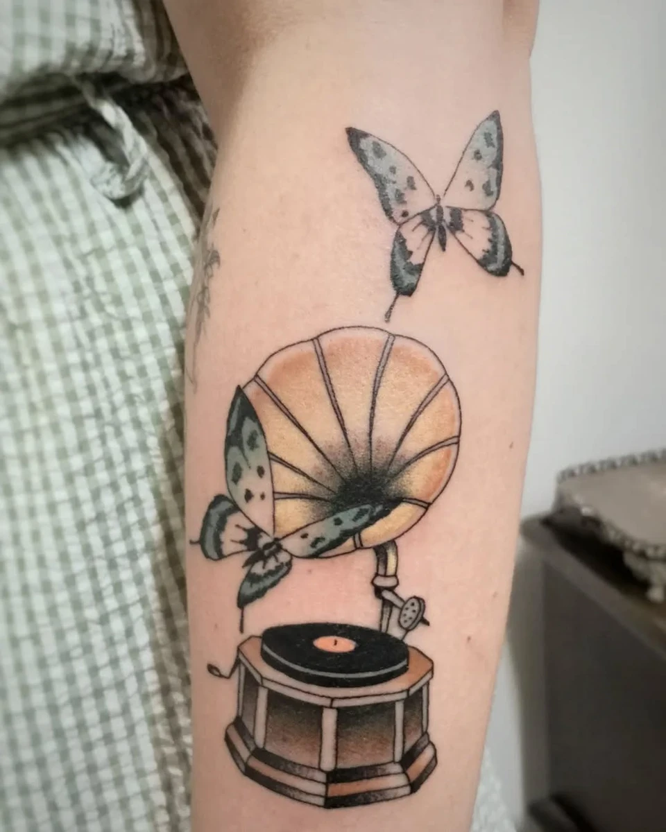 Gramophone vintage et papillon en couleur sur bras, style traditionnel