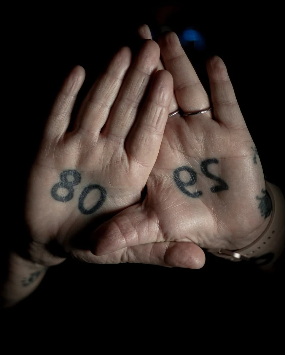 Tatouages cicatrisés dans les paumes d'Annabelle — chiffres 80 et 29 en noir