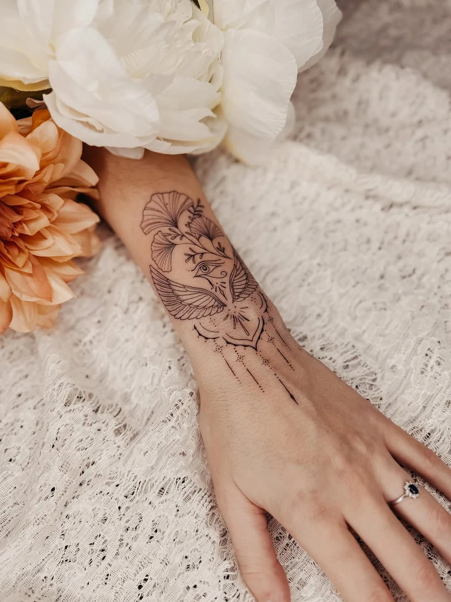 E G Y P T E & M O I. Un talisman posé sur la peau. Un œil qui veille, des ailes ouvertes, comme une promesse de protection silencieuse. Les lignes s'entrelacent, fines et calmes, elles racontent ce qui ne se dit pas toujours : la force intérieure, la transformation, la lumière qui persiste même dans